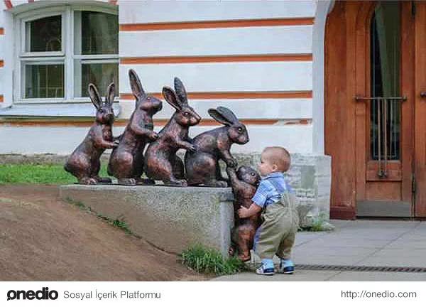 Arkadaşlarının yanına çıkmaya çalışan tavşan heykeline yardımcı olan bu ufaklık.